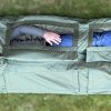 Person laying inside waterproof sleeping bag featuring hypothermia check openings for injury condition monitoring